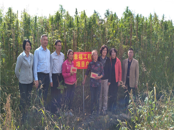郝林娜理事长一行与受助母亲高云翠、徐红在自家汉麻种植地前合影留念.jpg