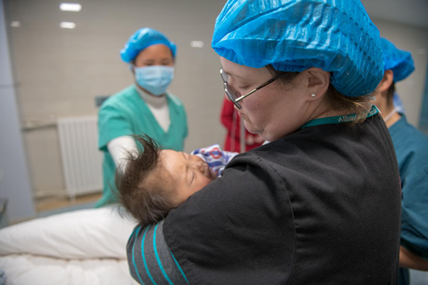 复苏室护士Traci Lee怀抱孩子，等待他从麻醉中完全醒来.png