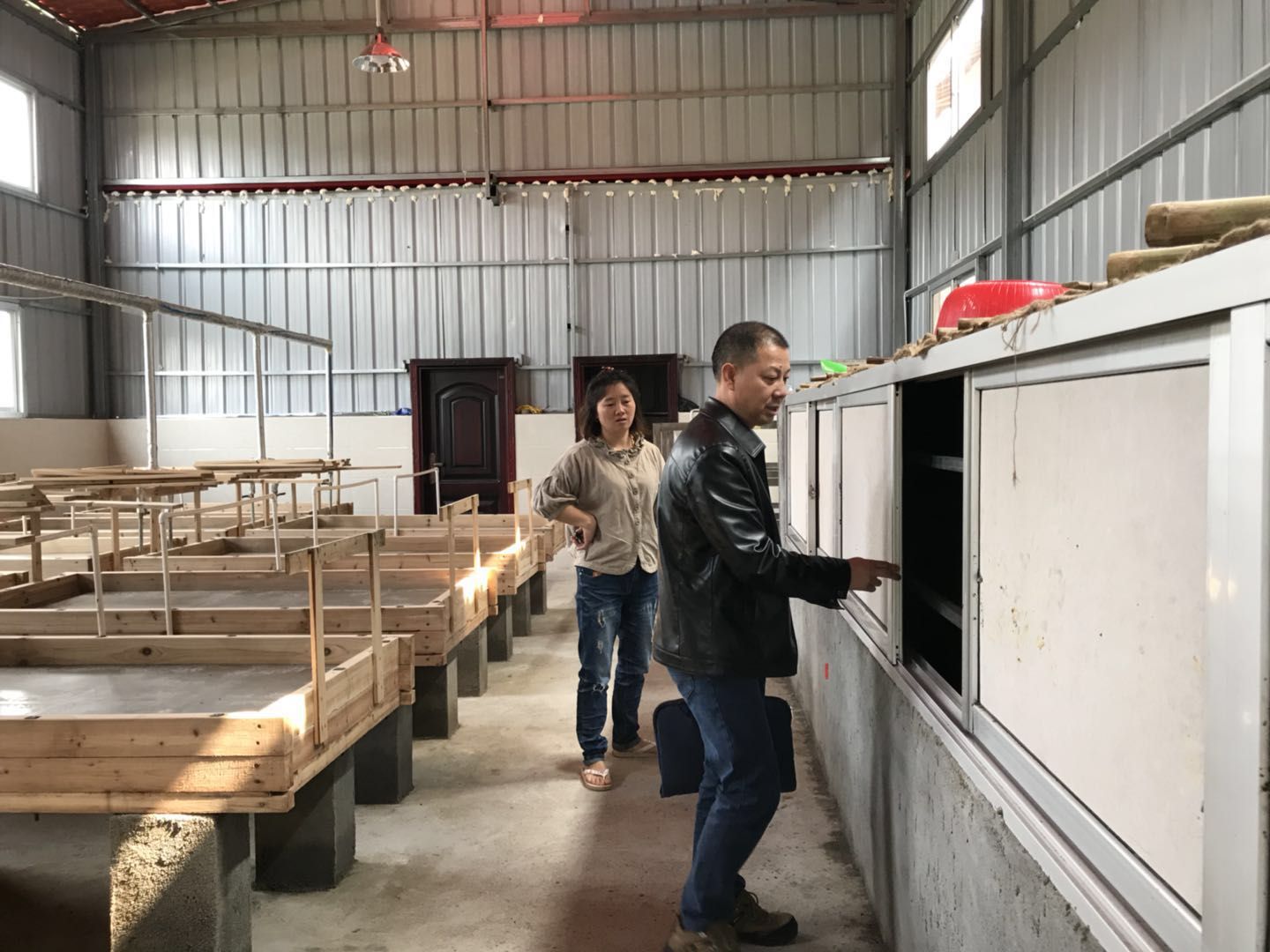 图为：清流县计生协会常务专职副会长罗学宽在贫困母亲的厂房里了解生产情况.jpg