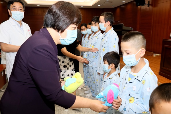 图3 自治区卫生健康委党组成员、计划生育协会专职副会长胡志春给患儿们发放小礼物 - 600.JPG